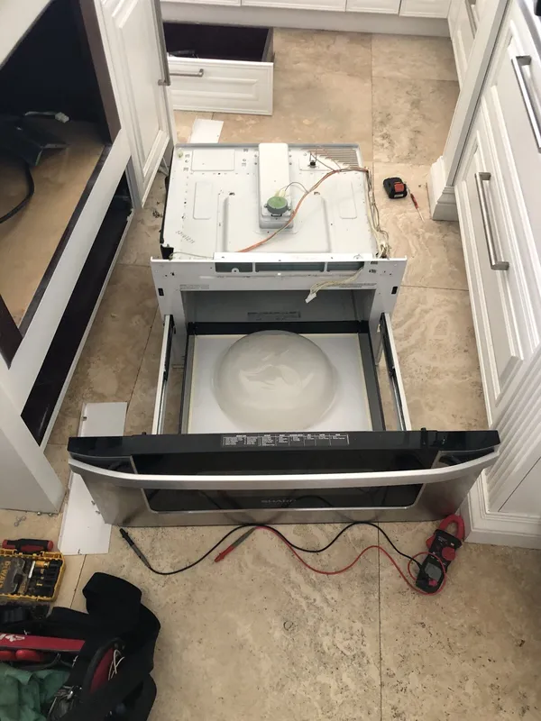 Microwave pulled out of the cabinet with the door open