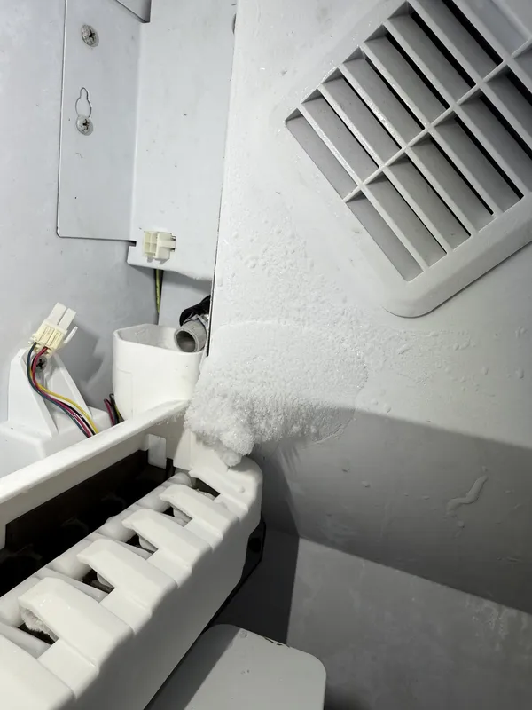 Ice buildup near the ice maker inside the refrigerator